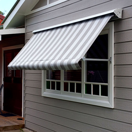 Pivot arm awning shielding a canberra home window