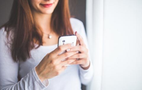 Woman using a smartphone to control blinds from The Blind Shop in Canberra